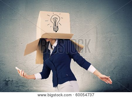 Businesswoman using mobile phone wearing carton box on head