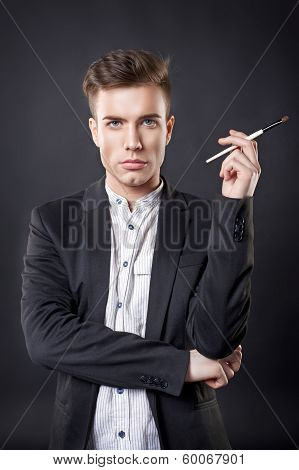 Stylish young handsome man in a suit with a brush.
