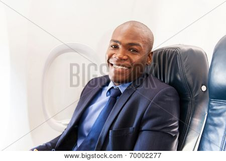 smiling african american airplane passenger relaxing during flight