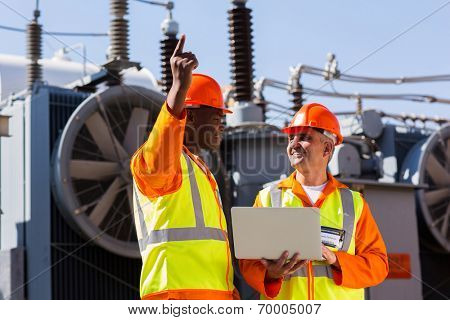 technical workers discussing work at electrical substation