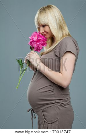 Pregnant woman smelling flowers.