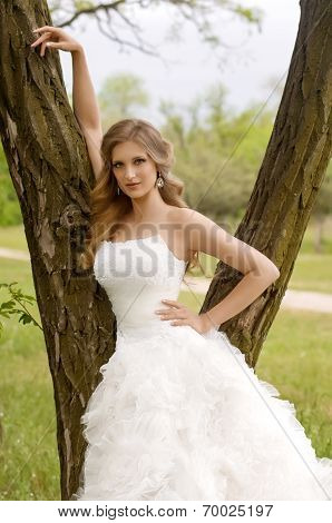 Beautiful bride in white dress in spring garden