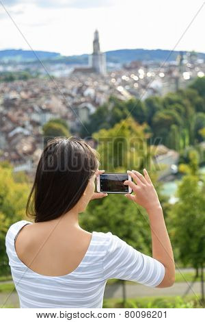 Tourist with smartphone camera in Bern, Switzerland at Rosengarten, the Rose Garden view. Woman taking photograph with smartphone at enjoying view of Berne landmarks and tourist attractions.