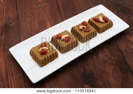 raw vegan halvah on white plate over wood background