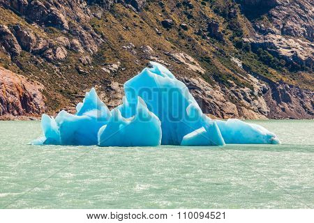 Argentina Patagonia, emerald water of the lake Viedma. Huge white-blue ice floe drifts from coastal glacier