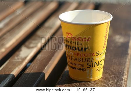 paper cup on the wooden bench