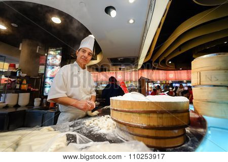 SINGAPORE - NOVEMBER 08, 2015: cook prepare food on the food court of The Shoppes at Marina Bay Sands. The Shoppes at Marina Bay Sands is one of Singapore's largest luxury shopping malls
