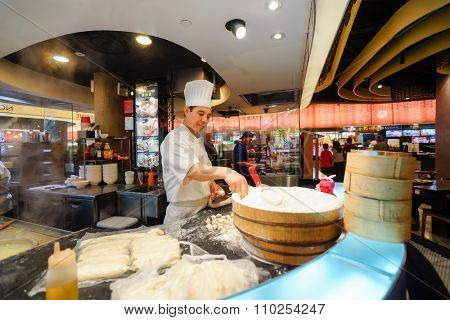 SINGAPORE - NOVEMBER 08, 2015: cook prepare food on the food court of The Shoppes at Marina Bay Sands. The Shoppes at Marina Bay Sands is one of Singapore's largest luxury shopping malls