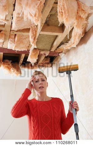 Woman Holding Mop Under Damaged Ceiling