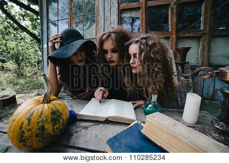 Three vintage witches perform magic ritual
