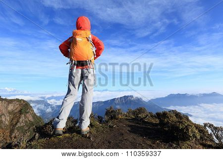 young woman backpacker hiking on mountian peak