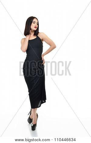 Full-length portrait of young fashion woman in black dress isolated on white background.