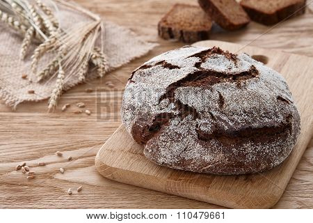 Round loaf of bread on a wooden background