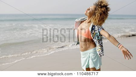 Young seductive african american girl near the sea, whirls and plays the fool in 