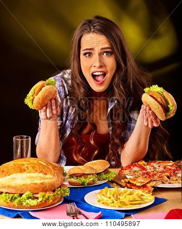Girl eat fastfood big hamburger and pizza .
