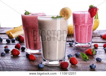 Glasses of fresh cold smoothie with fruit and berries, isolated on white