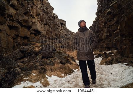 Independent woman tourist exploring the crack between tectonic plates in Thingvellir national park, Iceland