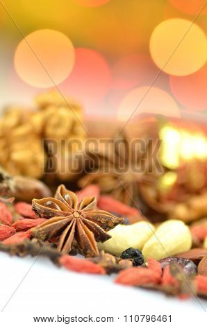 christmas spices, nuts, cookies and dried fruits on bokeh background
