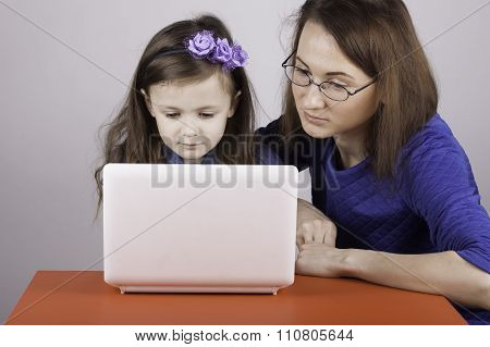 woman teaches a child work on the computer