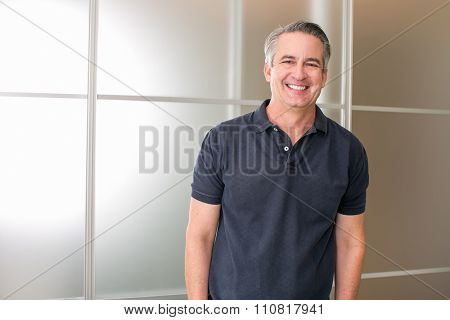 Happy casual mature business man in his office