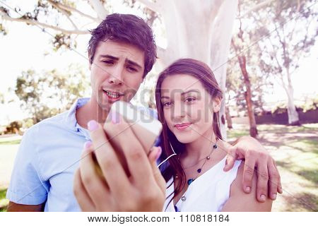 Young couple in the park making their selfi with mobile phone