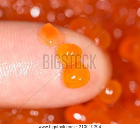 red caviar on a finger. close-up . photo in the studio