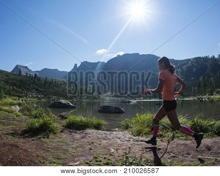ERGAKI, RUSSIA - AUGUST 05 2017: Unknown girl sportswoman running through the mountains, participant in the trailrunning contest SKAYRANFEST August 5, 2017 in the national park Ergaki, Russia