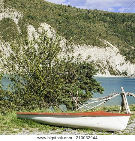Boat on the beach of the lake Castillon in France. Lake Castillon is a reservoir in Alpes-de-Haute-Provence in France.