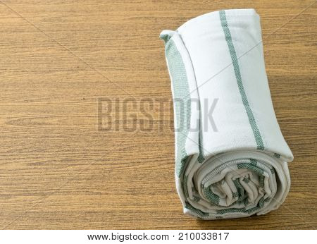 Kitchen Utensil White and Green Napkin Serviette or Kitchen Towel on Wooden Table with Copy Space for Text Decorated.