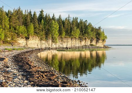Sunset on the beach. Limestone cliff in the sea under blue sky and white clouds. Kesselaid a small island in Estonia. Nordic countries Europe