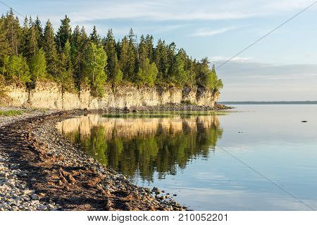 Sunset on the beach. Limestone cliff in the sea under blue sky and white clouds. Kesselaid a small island in Estonia. Nordic countries Europe