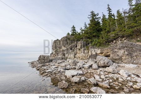 Sunset on the beach. Limestone cliff in the sea under blue sky and white clouds. Kesselaid a small island in Estonia. Nordic countries Europe