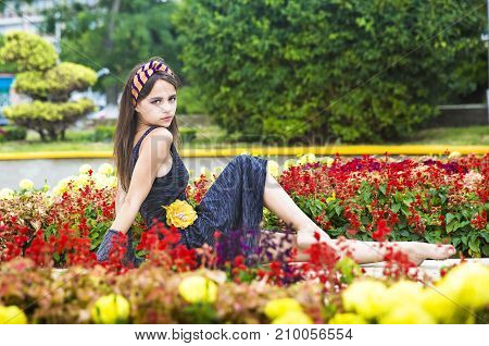 Beautiful young girl in a flower bed.