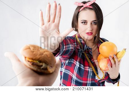 The Concept Of Healthy And Unhealthy Nutrition. The Model Plus Size Makes A Choice In Favor Of Healt
