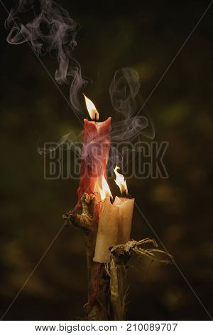 Red And White Candles Burn On A Staff With Magical Smoke