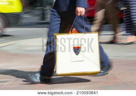 LONDON, UK - June 9, 2017: Blurred image of walking man with shopping bag at Oxford street, the main destination for shopping at Westend.