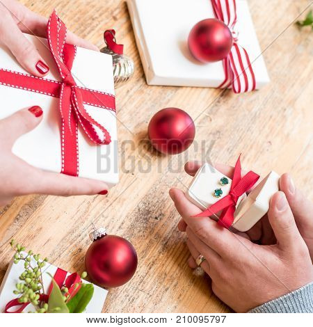 Romantic couple gives holiday Christmas gifts with red bows and Christmas deocorations