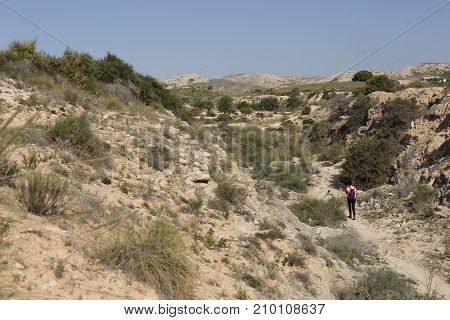 Woman walking in the mountains of Elche Alicante province in Spain.