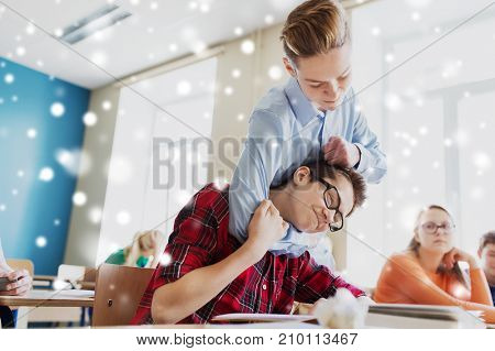 education, bullying, violence, aggression and people concept - student boy suffering of classmate mockery over snow