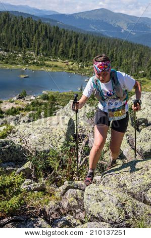 ERGAKI, RUSSIA - AUGUST 05 2017: Unknown girl sportswoman running through the mountains, participant in the trailrunning contest SKAYRANFEST August 5, 2017 in the national park Ergaki, Russia