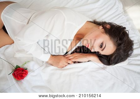 nice girl in lingerie lying on a bed with a rose