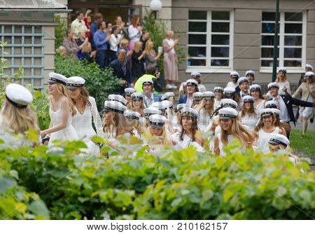 Stockholm Sweden - Jun 13 2017: Happy Teenagers Wearing Graduation Caps Running Out From School Afte