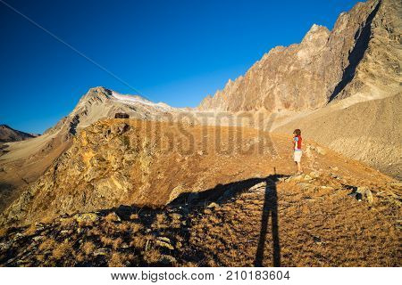 One Person Looking At View High Up On The Alps. Expasive Landscape, Idyllic View At Sunset. Rear Vie