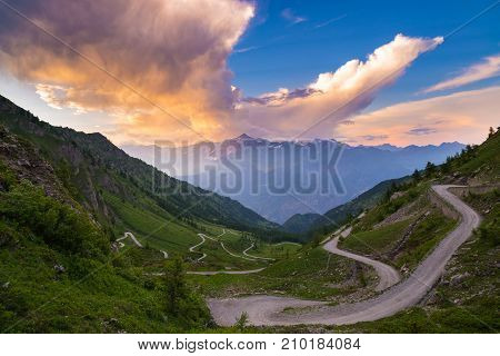 Mountain Road Leading To High Mountain Pass On The Italian Alps.. Expasive View At Sunset, Colorful
