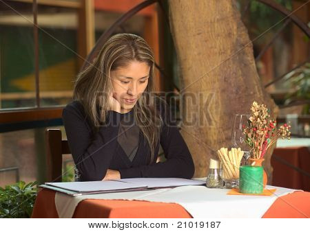 Peruánská žena při pohledu na Menu v restauraci