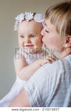 happy family. Mother and baby daughter plays hugging kissing at hom