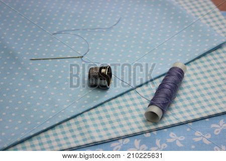 Multicolored cuts of fabric with coils of thread on the background of boards