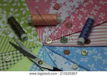 Multicolored cuts of fabric with coils of thread on the background of boards