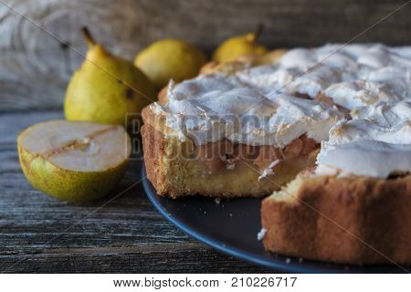 delicious homemade pie stuffed with fresh pear and meringue on wooden Board