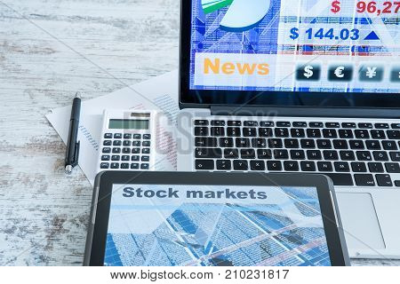 Stock market calculations with a calculator and research software on a Tablet PC with a Laptop computer.